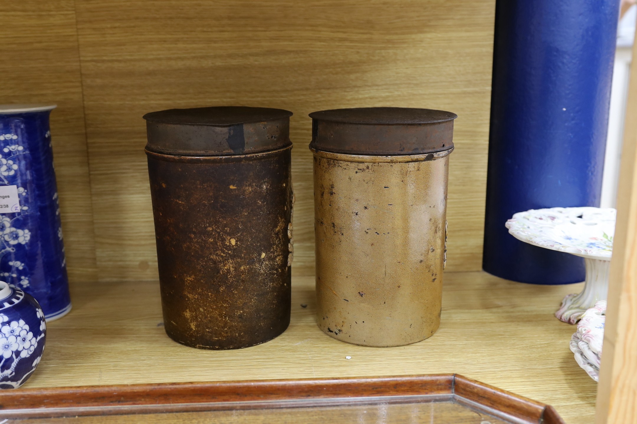 A pair of 19th century cylindrical salt glazed stoneware canisters, with Royal coat of arms sprigging, 26cm tall